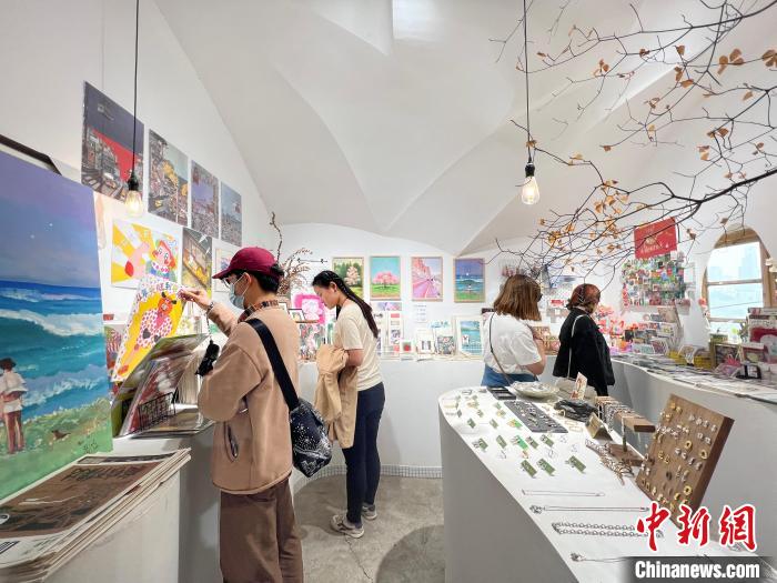 圖為藝術品商店內，顧客挑選插畫作品。　鐘旖 攝