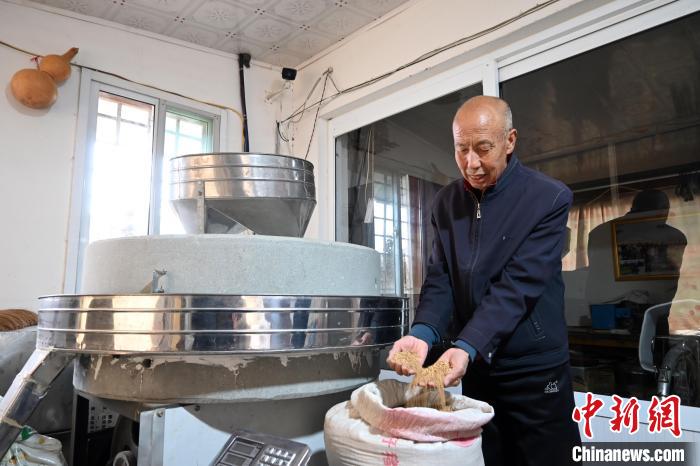 李家莊村民谷文朝重拾父輩的手藝，做起石磨面粉的營生。　翟羽佳 攝