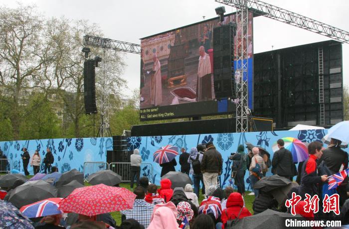 當(dāng)?shù)貢r(shí)間5月6日，英國(guó)國(guó)王查爾斯三世的加冕儀式舉行。民眾雨中觀看儀式。　歐陽(yáng)開宇 攝