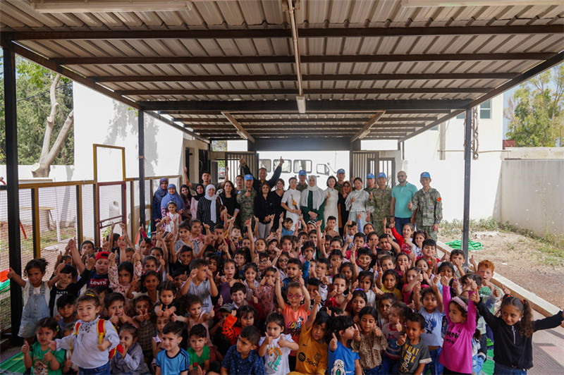 當(dāng)?shù)貢r(shí)間5月30日，黎巴嫩南部庫雷拉公立小學(xué)，“六一”國際兒童節(jié)前夕，中國第21批赴黎維和多功能工兵分隊(duì)官兵看望慰問學(xué)校師生，并開展文化交流活動，圖為我維和官兵同師生合影。李竹林?jǐn)z