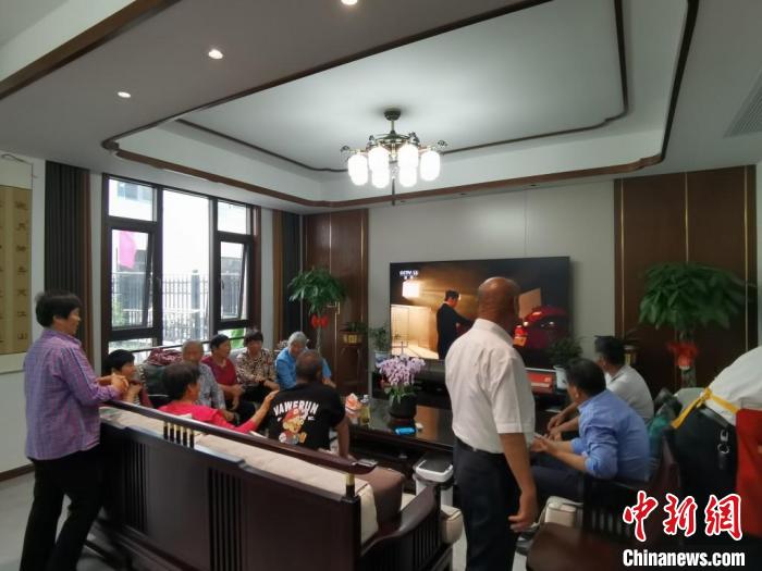 親友們集中在費(fèi)俊龍家中觀看返程的視頻。　鐘升 攝