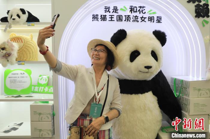 美國華視總裁楊蓮花與大熊貓文創產品合影。　王磊 攝