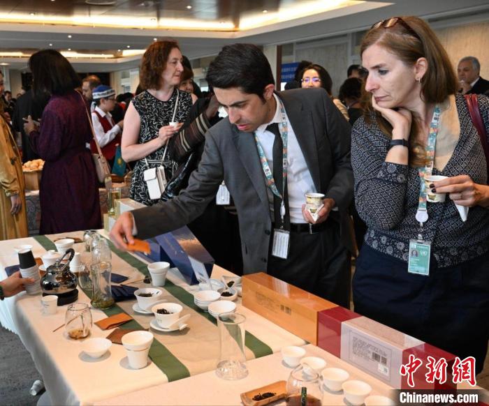 現場觀眾觀看中國展臺茶藝表演、了解茶文化?！【笜?攝