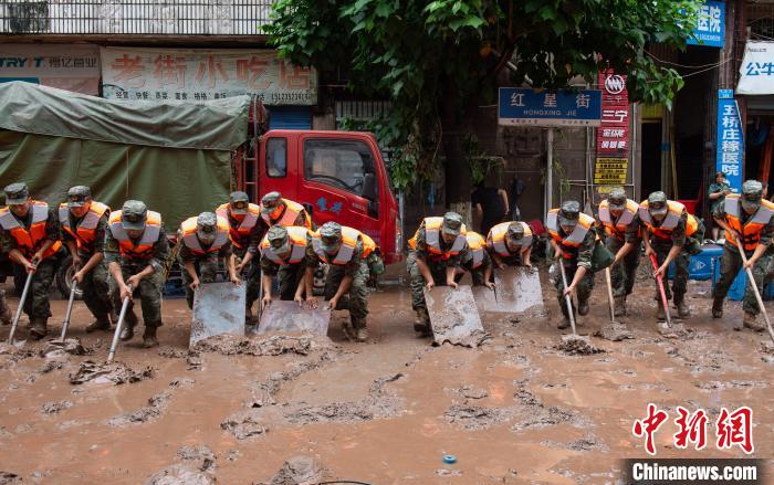 7月4日，萬州區五橋街道，武警官兵清理街道上的淤泥。　冉孟軍 攝