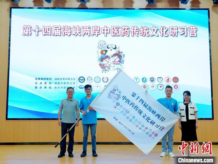 共青團福建省委副書記吳雪(右一)、福建中醫(yī)藥大學黨委副書記林羽(左一)為兩岸學生代表頒授營旗。　許燁婷 攝