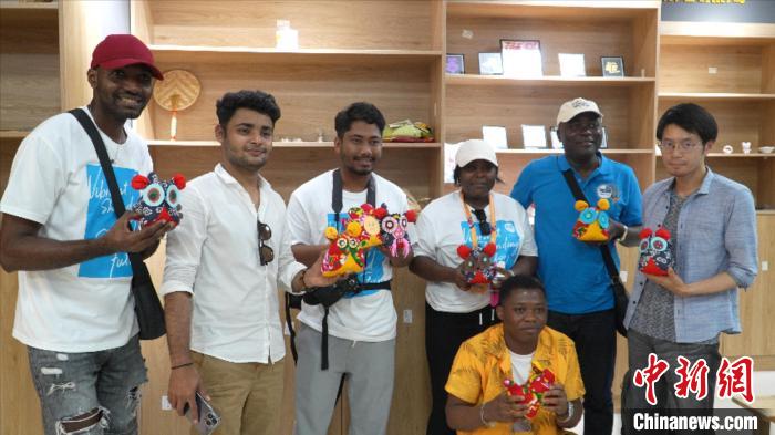 圖為國際青年代表展示親手制作的東營非遺黃河口布偶 。　齊魯 攝