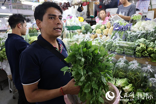 7月19日，泰國曼谷藍(lán)象餐廳員工向參加活動的多國代表介紹如何挑選新鮮蔬菜。 人民網(wǎng)記者 張矜若攝