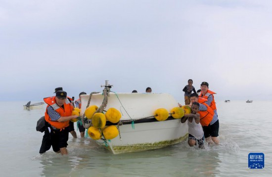 7月21日，中國海軍“和平方舟”號醫院船醫護人員涉水登島，前往基里巴斯一診療點。新華社記者 黎云 攝