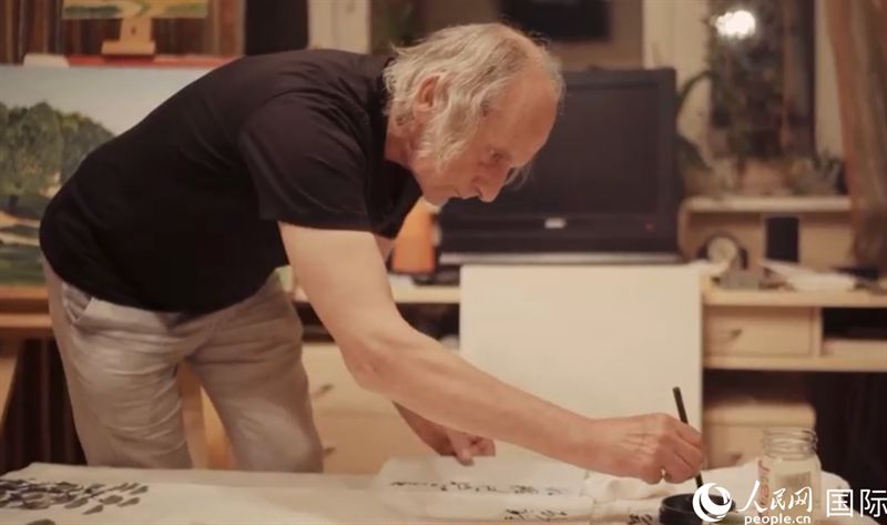 伊戈爾·布爾東諾夫在畫作上題詞。人民網記者 馬天翼攝