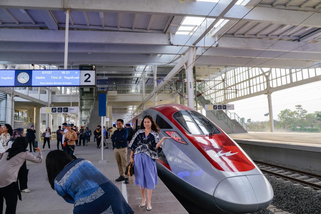 10月17日，在印度尼西亞萬隆德卡魯爾站，乘客在站臺上和雅萬高鐵高速動車組列車合影。