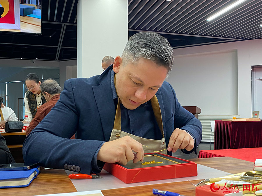 2023“一帶一路”媒體合作論壇聯合采訪團團員，親身體驗景泰藍工藝。人民網記者 于洋攝