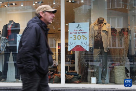   10月31日，一名男子從比利時布魯塞爾一家貼有打折信息的店鋪前走過。新華社記者 趙丁喆 攝