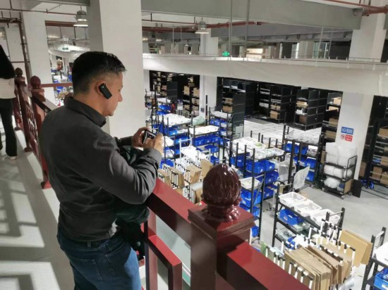 2023“一帶一路”媒體合作論壇聯合采訪團團員在仁和醫藥物流園拍攝記錄轉運流程。（本報記者 黃超攝）