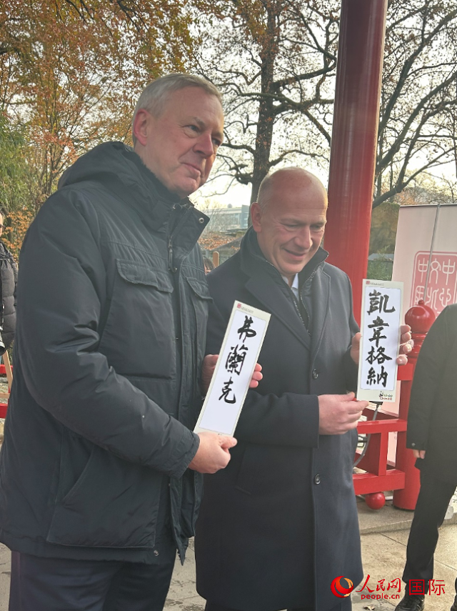 柏林市長韋格納（右）、動物園監事會主席布魯克曼（左）手持中國文化中心工作人員現場手書的中文名字。人民網記者 徐馨攝