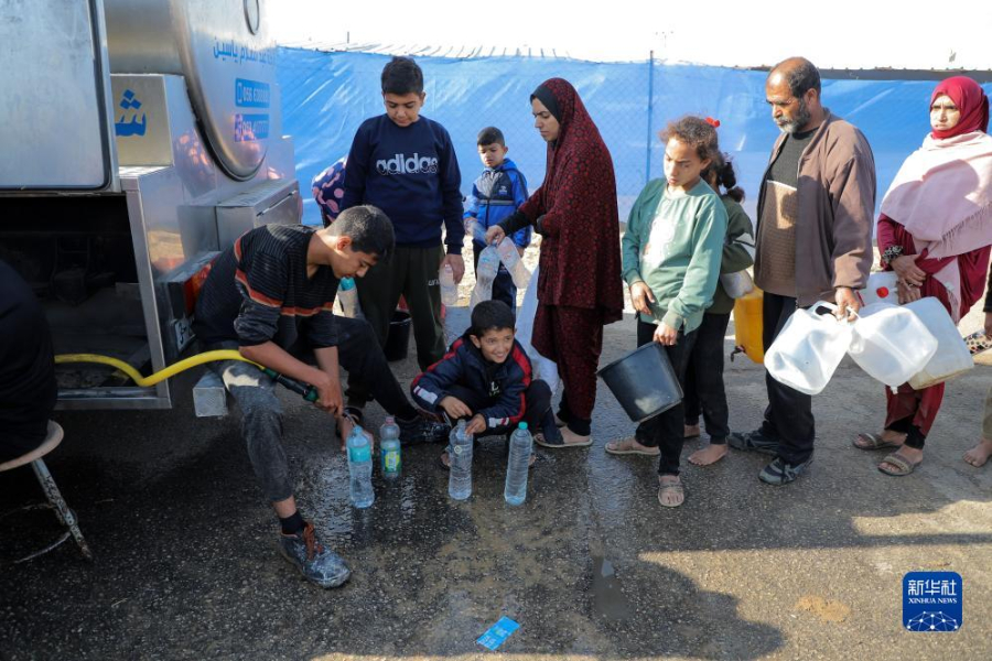 12月8日，在加沙地帶南部城市拉法一處臨時(shí)營地內(nèi)，人們排隊(duì)打水。新華社發(fā)（里澤克·阿卜杜勒賈瓦德 攝）