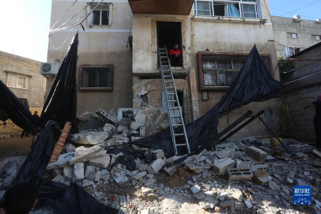 12月17日，在約旦河西岸城市圖勒凱爾姆附近的一處難民營，人們查看在沖突中損毀的房屋。新華社發（尼達爾·艾仕塔耶攝）