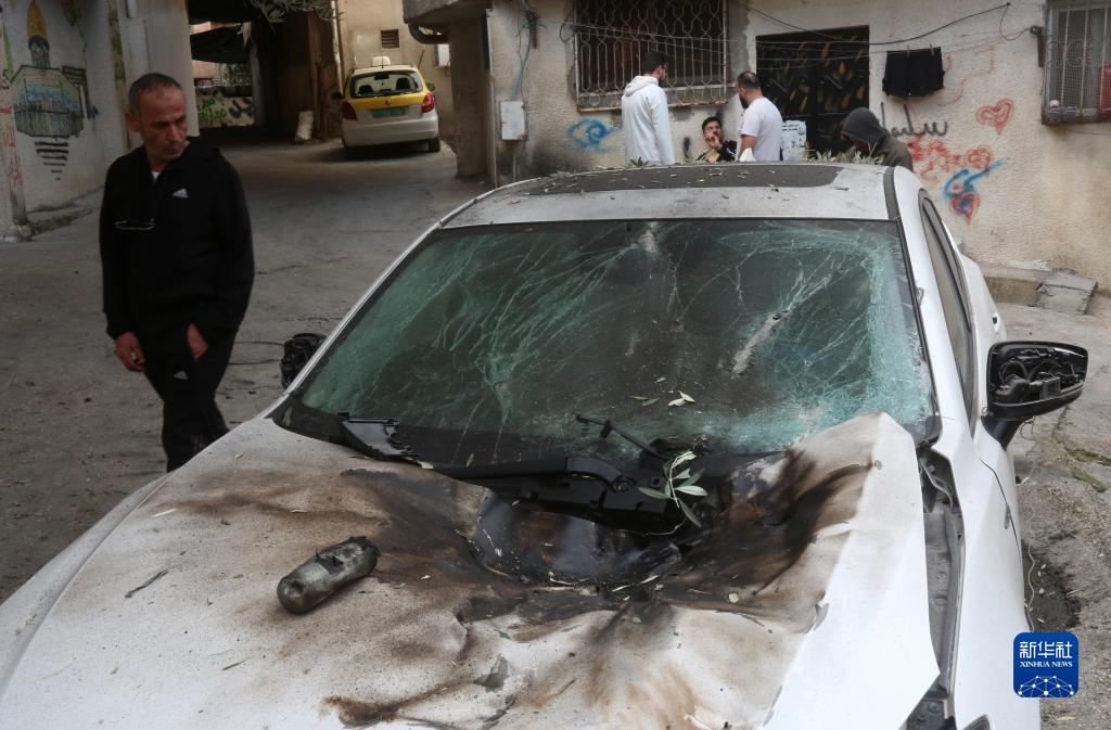 12月17日，在約旦河西岸城市圖勒凱爾姆附近的一處難民營，人們查看在沖突中損毀的車輛。新華社發（尼達爾·艾仕塔耶攝）