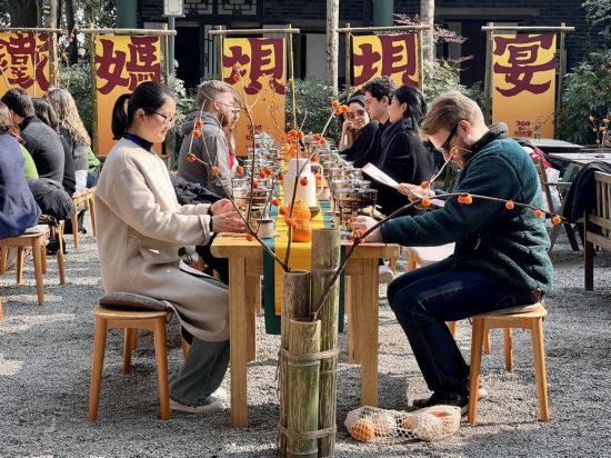 哥倫比亞大學青年學生代表團與蒲江縣鐵牛村村民一起交流、品嘗當地的小火鍋。