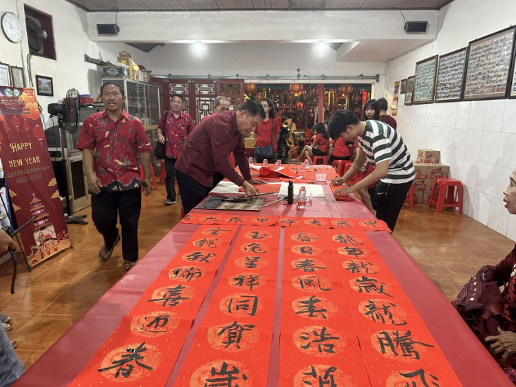 茍皓東為華人朋友現場寫春聯送福字。巴陵康孔子學院供圖