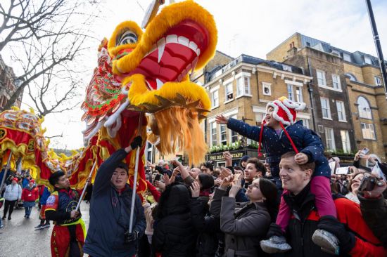 2月11日，人們在英國倫敦的新春巡游活動中觀看舞龍表演。新華社發（史蒂芬·程攝）