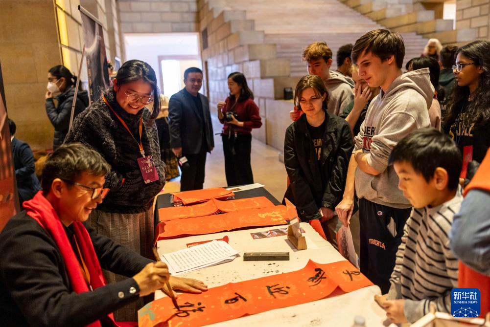 2月11日，書法家在美國費城藝術博物館舉行的龍年迎新春活動上為參觀者書寫對聯。新華社發（周煥新攝）