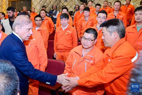 4月1日，在巴基斯坦西北部開伯爾-普什圖省達蘇，巴基斯坦總理夏巴茲（左）同達蘇水電站項目中方員工握手。新華社發（巴基斯坦新聞與廣播部下轄媒體信息部門供圖）