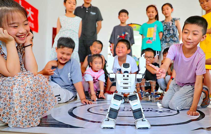 2022年7月19日，河北省秦皇島市海港區白塔嶺街道秦皇半島第二社區內，小朋友正在觀看“機器人跳舞”。 曹建雄攝