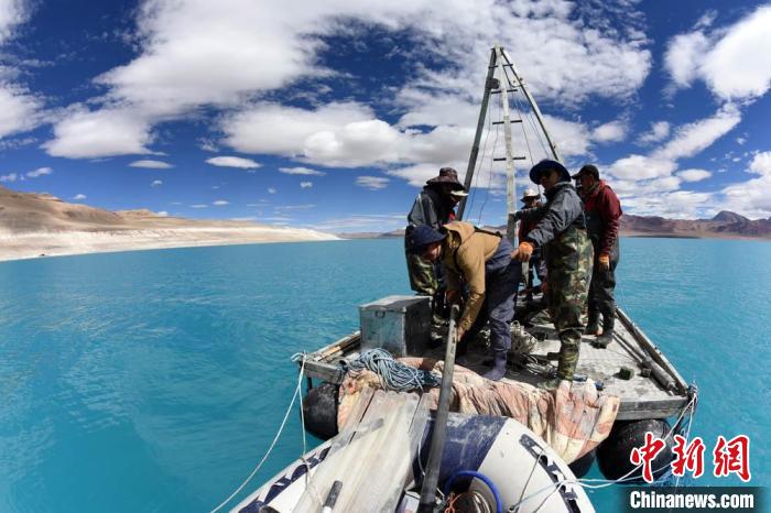 科考隊(duì)員在湖泊鉆探平臺(tái)上小心搬運(yùn)采集的巖芯樣品。　<a target='_blank' ><p  align=