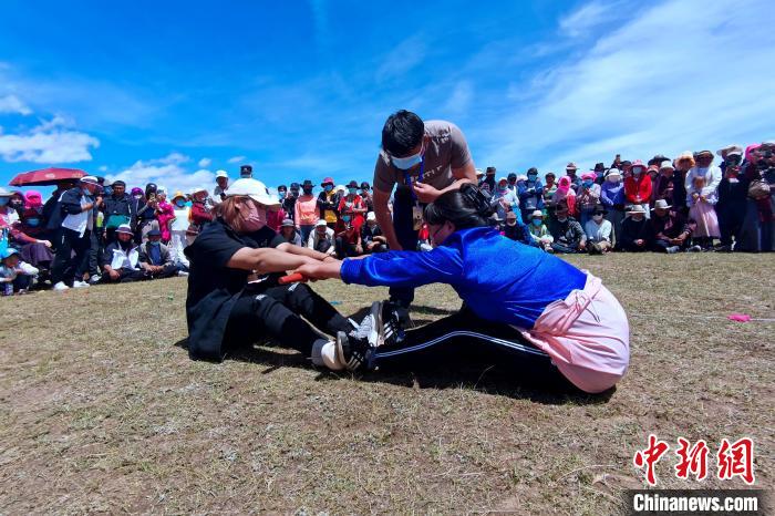 圖為當地民眾進行蹬棍比賽?！±铍h 攝