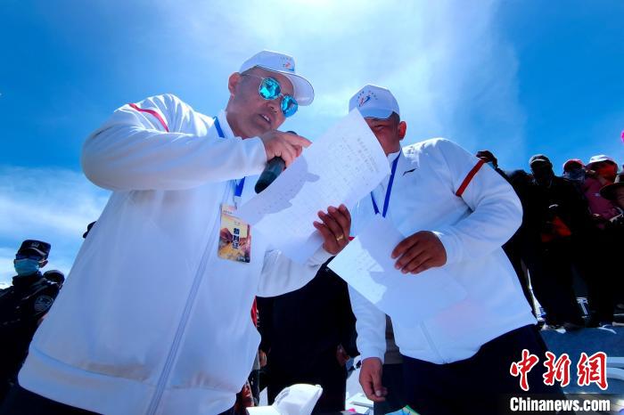 圖為裁判員統(tǒng)計牧民運動項目比賽成績。　李雋 攝