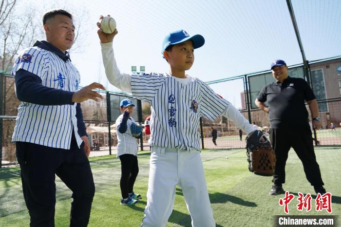 圖為教練指導小棒球手擲球技術?！●R銘言 攝