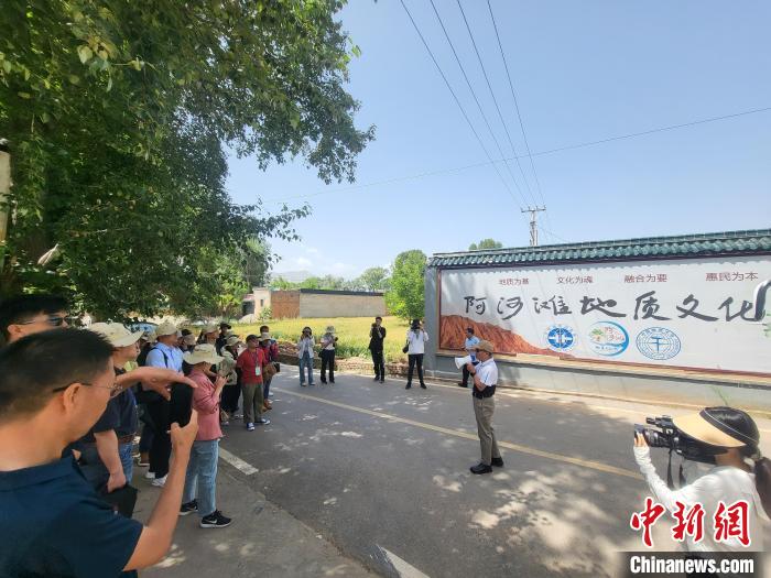 圖為中國地質大學(北京)教授張緒教介紹村落情況。 胡友軍 攝