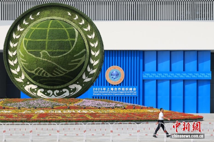 8月31日，天津，一名工作人員從2025年上海合作組織峰會主會場外的景觀花壇旁經過。當日，2025年上海合作組織峰會在天津舉行。<a target='_blank' href='/'><p  align=