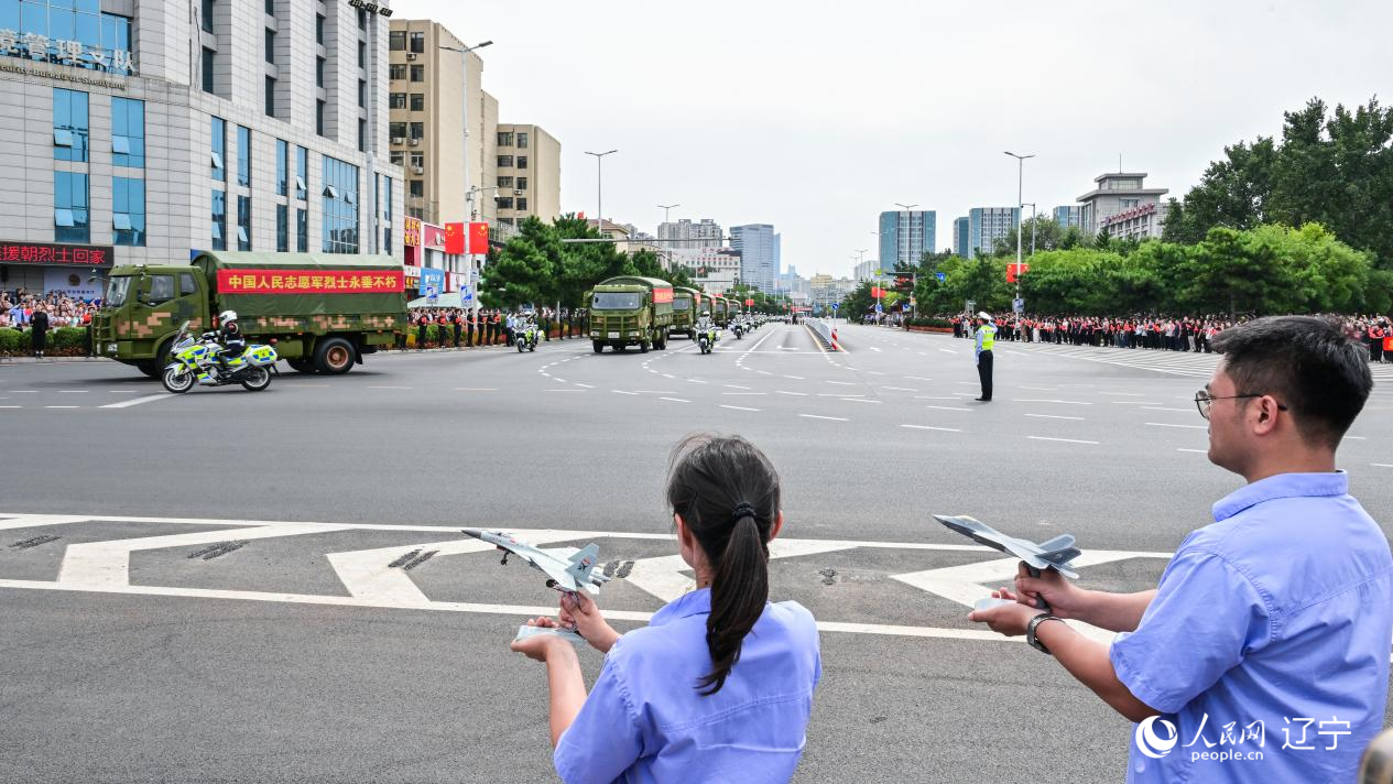 航空工業沈飛的青年技術人員拿著受閱戰機的模型迎接烈士遺骸。航空工業沈飛供圖