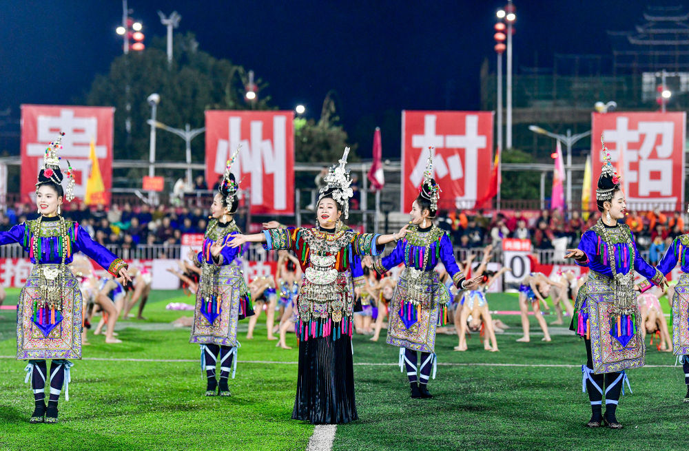 2025年3月14日，2025年貴州“村超”40強交叉賽在榕江“村超”足球場舉行，演員在比賽間隙表演侗族大歌，民族文化伴隨著體育賽事成功“出圈”。圖片來源：新華社