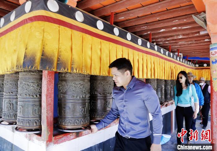 圖為外籍嘉賓體驗藏族傳統轉經筒。　馬銘言 攝