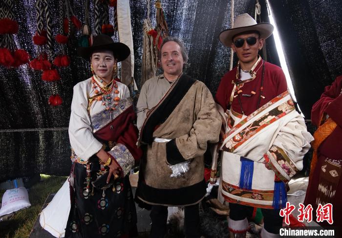 圖為一名外籍攝影師(中)身穿藏服和藏族民眾合影留念。　馬銘言 攝