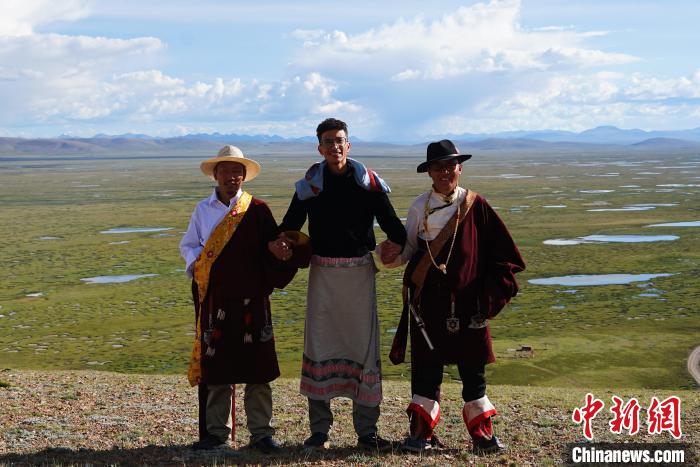 圖為一名留學生身穿自己國家的服飾和藏族民眾合影留念。　馬銘言 攝