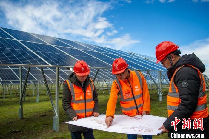 施工技術人員正在認真核查柯拉一期光伏電站相關設計數據等。　劉忠俊 攝