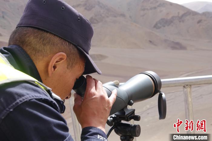 索朗曲扎用望遠鏡查看邊境情況。　冉文娟 攝