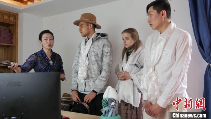 圖為圖為主播白瑪旺姆為留學(xué)生介紹直播流程?！≈x牧 攝