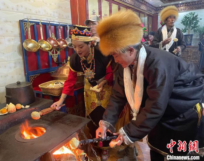 圖為人們?cè)诨鹕峡竟?jié)日美食“結(jié)達(dá)”。　冉文娟 攝