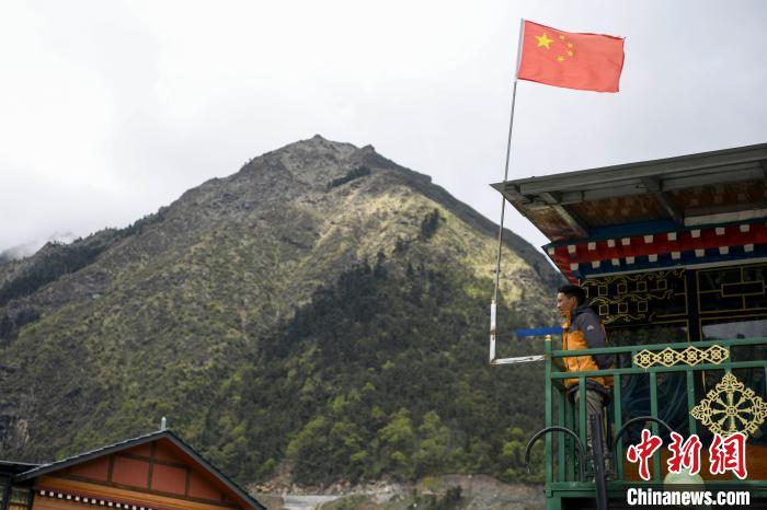 村民站在樓房上觀望。　楊華峰 攝