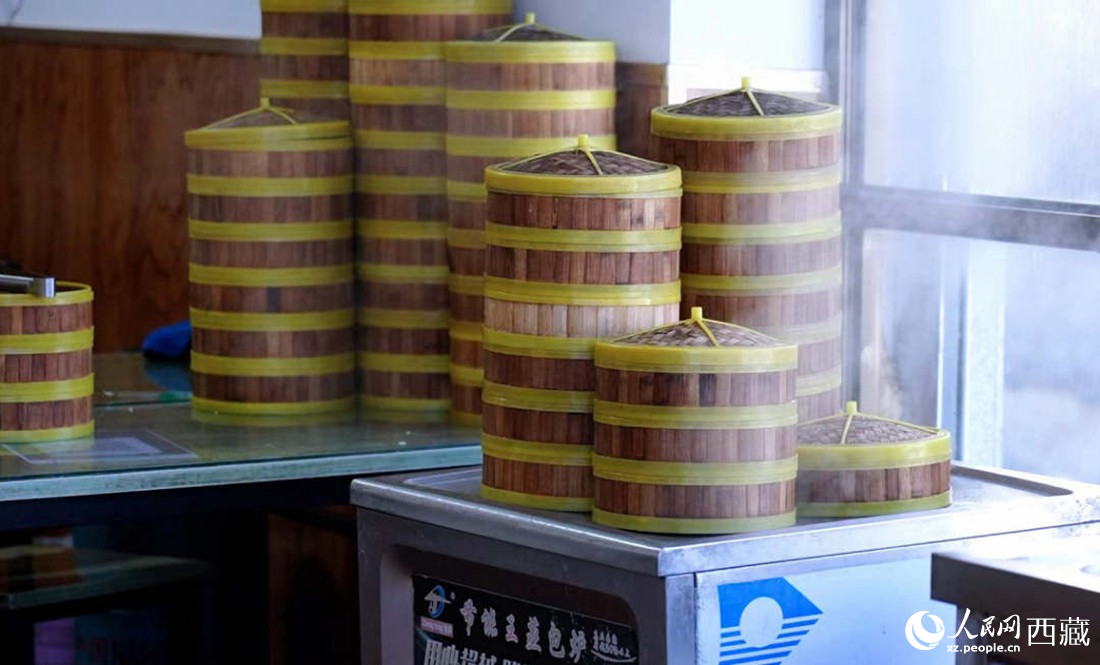 電蒸箱上擺滿了多屜熱氣騰騰的包子。人民網 次仁羅布攝