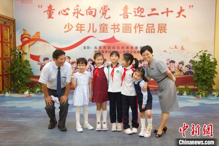 圖為與會嘉賓與入選畫作的“小作者”們在展覽上合影?！≈袊貙W研究中心供圖