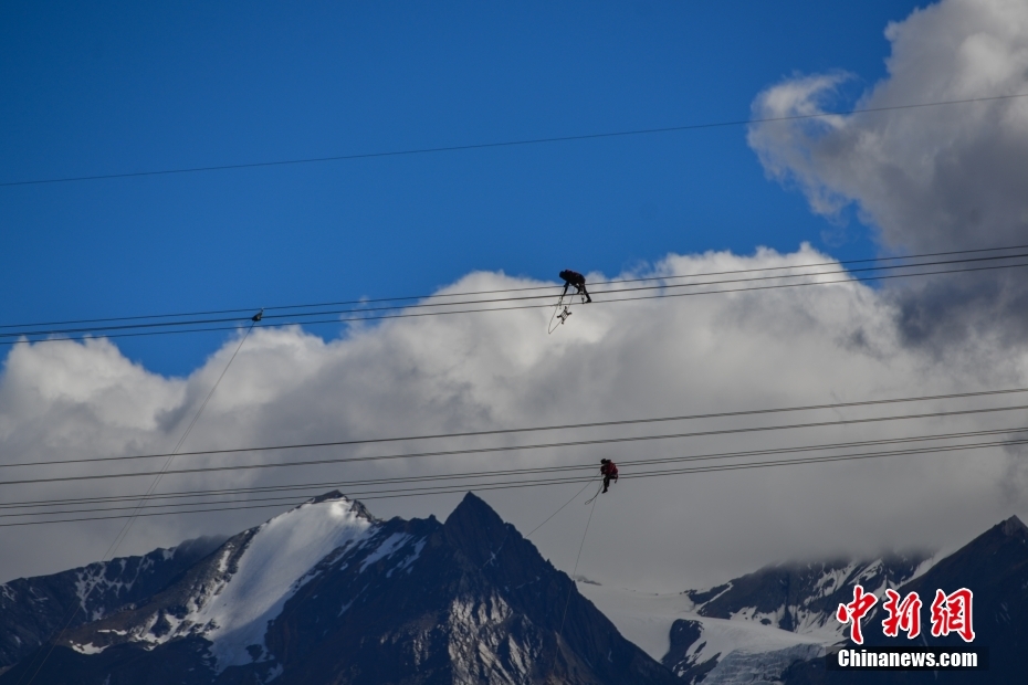 資料圖為2020年6月23日,西藏阿里聯(lián)網(wǎng)工程施工人員在日喀則希夏邦馬雪山附近進(jìn)行走線作業(yè),安裝絕緣設(shè)備。 <a target='_blank' href='/'><p align=