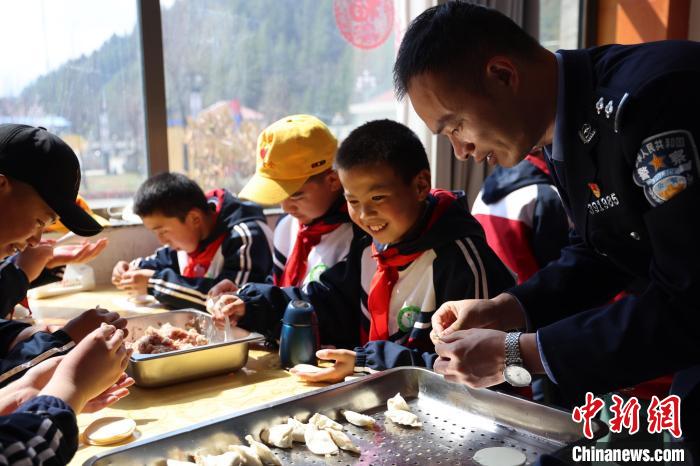 圖為亞東邊檢站民警與駐地小學生其樂融融包餃子。　胡利媛 攝