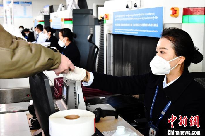 圖為機場工作人員為旅客辦理行李托運。　周航 攝