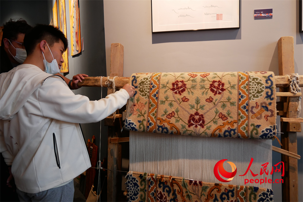 觀眾正在觀賞展出的藏毯。人民網(wǎng) 韋衍行攝