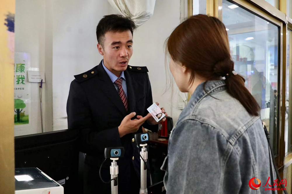 車站工作人員向旅客解答疑問。人民網記者 次仁羅布攝